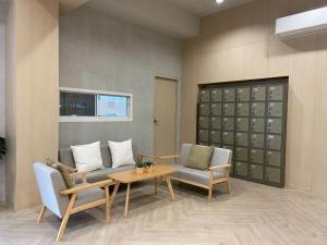a living room with two chairs and a table at Next Bird Suite SHA in Nonthaburi