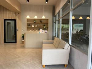 a lobby with a white couch and a counter at Next Bird Suite SHA in Nonthaburi +10 photos