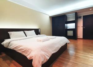 a bedroom with a large bed with two towels on it at Next Bird Suite SHA in Nonthaburi