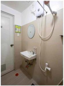 a bathroom with a sink and a mirror and a shower at Yuj Inn Pasay in Manila