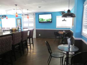 un comedor con paredes azules, mesas y sillas en Oasis Boutique Motel en Boulder City