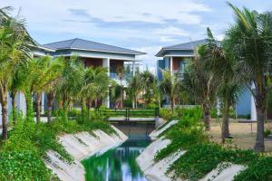 un complejo con piscina y palmeras en Sea Star Resort, en Dong Hoi