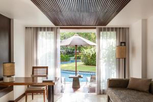 a living room with a table and an umbrella at Melia Bali in Nusa Dua