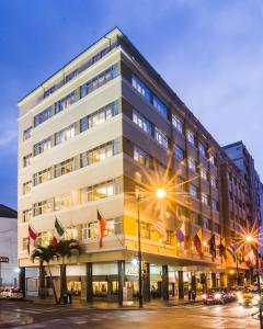 ein großes Gebäude mit Flaggen davor in der Unterkunft Hotel Palace Guayaquil in Guayaquil