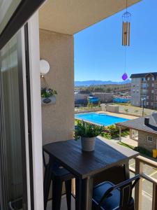 een balkon met een tafel en uitzicht op een zwembad bij Departamento para 6 personas in Villarrica