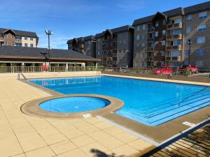 a large swimming pool in front of a building at Departamento para 6 personas in Villarrica
