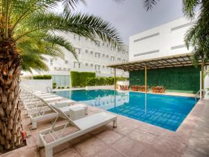 una piscina de hotel con tumbonas y un edificio en Capital O 827 Speciale Hotel, en Rosario