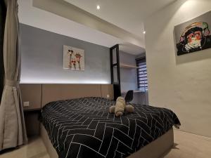 - une chambre avec un lit avec un animal rembourré dans l'établissement Pax6+2 Melaka Famous Homestay Klebang Homefeel, à Malacca