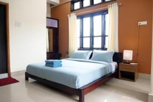 a bedroom with a large bed with a window at JOY'S BNB in Imphal