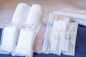 a group of white towels sitting next to a bed at Stay SAKURA Kyoto Shijo Karasuma in Kyoto