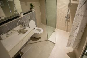 a bathroom with a toilet and a glass shower at ROSA BELLA in Nizwa