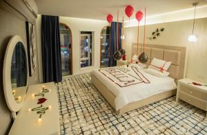 a bedroom with a bed and a table and red balloons at ROSA BELLA in Nizwa