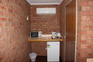 a small kitchen with a brick wall at Red Cliffs Colonial Motor Lodge, Mildura Region in Red Cliffs