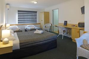 A bed or beds in a room at Warwick Vines Motel