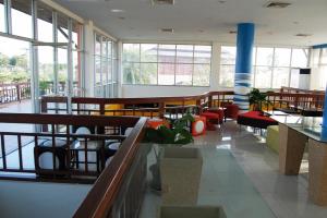 a large room with chairs and tables and windows at The Adventure Hotel in Chiang Mai