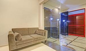 a living room with a couch and a glass door at Itsy By Treebo - Sunrise Grand in Hyderabad