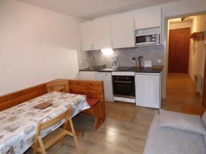 cocina con mesa y cocina pequeña con mesa y sillas en Studio Valloire, 1 pièce, 3 personnes - FR-1-263-8, en Valloire