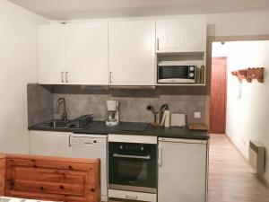 a kitchen with white cabinets and a stove top oven at Studio Valloire, 1 pièce, 3 personnes - FR-1-263-8 in Valloire