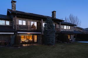 a large house with a balcony and a table at Casa Fontanals de Cerdanya in Soriguerola