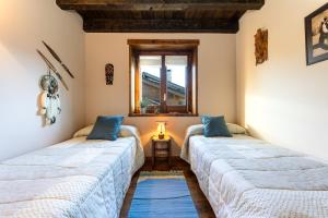 two beds in a room with a window at Casa Fontanals de Cerdanya in Soriguerola