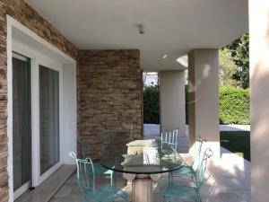 um pátio com uma mesa e cadeiras e uma parede de tijolos em Beautiful Modern Villa In Isola Albarella em Ilha Albarella