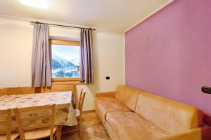 een woonkamer met een bank, een tafel en een raam bij Viola in Livigno
