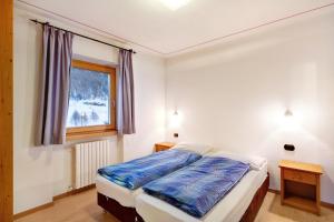 een slaapkamer met een bed en een raam bij Viola in Livigno