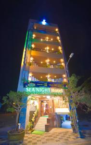 ファンティエットにあるSea Night Hotelの看板が目の前にある高層ビル