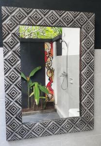specchio da bagno con dipinto sul muro di Indah Homestay and Cooking classes a Senggigi