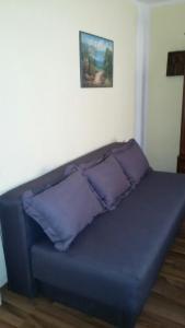 a blue couch with two pillows in a room at Studios Milošev in Bar
