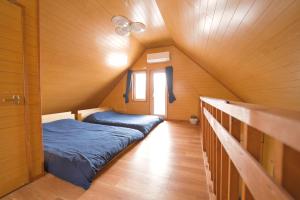 una habitación con 2 camas y una ventana en una casa en LAKE TOYA PREMIUM CABIN, en Lago Toya