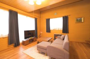sala de estar con sofá y TV en LAKE TOYA PREMIUM CABIN, en Lago Toya