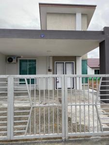 a white fence in front of a house at Twilight Imani Homestay Changlun in Changlun