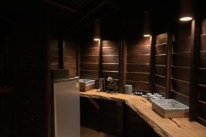 a kitchen with a counter with a refrigerator and a sink at The Rock Lodge in Ban Nahin-Nai (1)