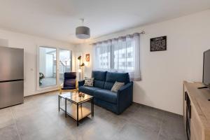 ein Wohnzimmer mit einem blauen Sofa und einem Tisch in der Unterkunft Le Concert - Beautiful appartment with garage for 4 people near beach in Annecy