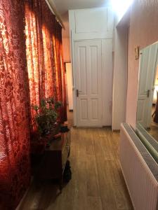 a hallway with a white door and a red curtain at Rimma Homestay in Tbilisi City