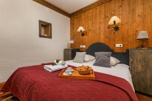 a bedroom with a large bed with a wooden wall at Résidence Le Cristal - Grands Montets 7 - Happy Rentals in Chamonix