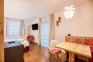 une chambre d'hôtel avec un lit et une table dans l'établissement Chalet Osmar Suite 1, à Campitello di Fassa