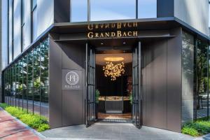 uma porta para um grande edifício preto com um lustre em Hotel GrandBach Tokyo Ginza em Tóquio