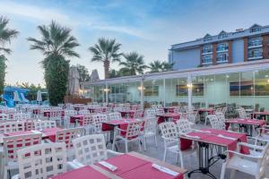 ケメルにあるArmas Beachの赤と白のテーブルと椅子が備わるレストラン