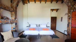 a bedroom with a bed with orange pillows on it at Karivo in Eorondemba