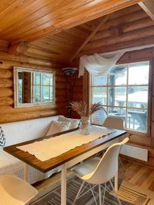 ein Esszimmer mit Tisch und Stühlen in der Unterkunft Villa Konnekoski, pearl front of Etelä-Konnevesi National park in Rautalampi
