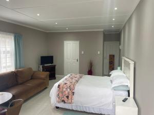 una camera con letto e divano di Hidden Bliss Guesthouse a East London