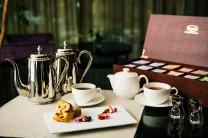 une table avec deux tasses de café et une assiette de nourriture dans l'établissement Hotel GrandBach Tokyo Ginza, à Tokyo