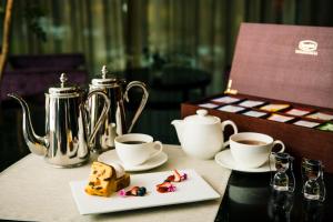 a table with two cups of coffee and a plate of food at Hotel GrandBach Tokyo Ginza in Tokyo