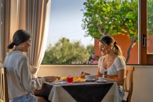 two women sitting at a table eating food at Hotel Il Girasole in Anacapri