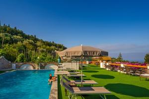 a pool at a resort with tables and chairs at Hotel Il Girasole in Anacapri