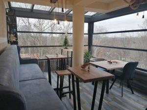 a restaurant with two tables and a couch and windows at Beo Green View in Belgrade