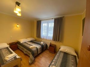 ビャウカにあるPokoje Gościnne Majaのベッドが2つと窓があるホテルの部屋