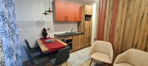 una cucina e una sala da pranzo con tavolo e sedie di Apartman Mina Jezero a Divčibare